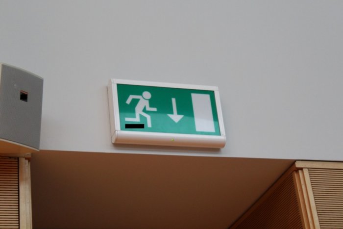 Oprawa oświetlenia awaryjnego wskazująca drogę ewakuacji z obiektu.