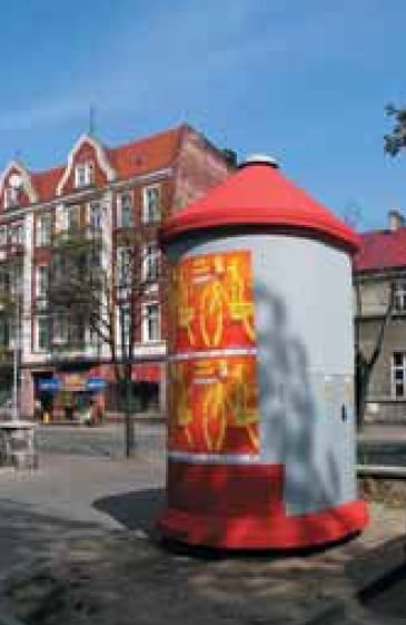 fot 4 slupowa stacja transformatorowa w ksztalcie slupa znajdujaca sie w centrum miasta