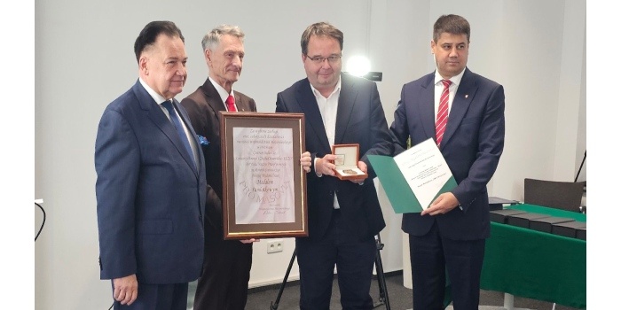 kilka osób pokazuje dyplomy i nagrody