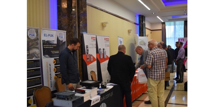 ludzie oglądający wystawę sprzętu elektrycznego
