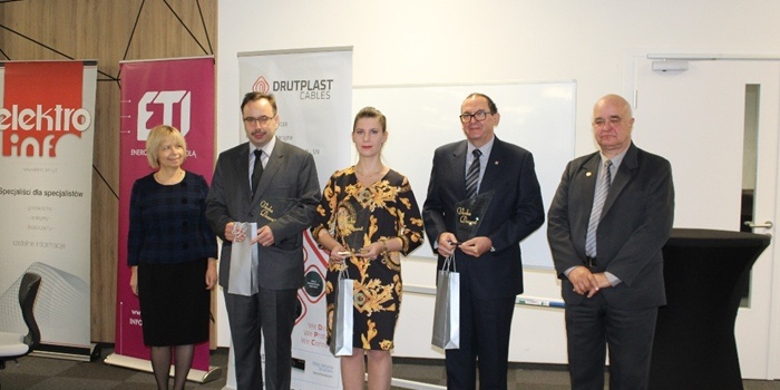 kilka osób stoi z nagrodami w rękach